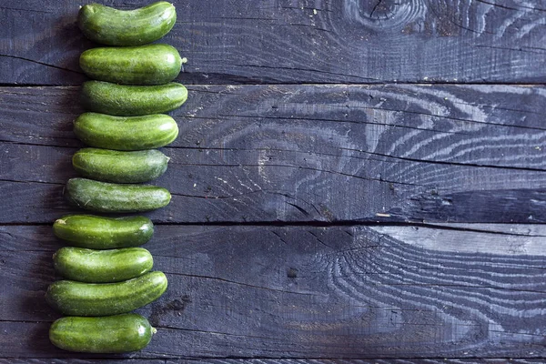 Fila de pepinos sobre madera — Foto de Stock