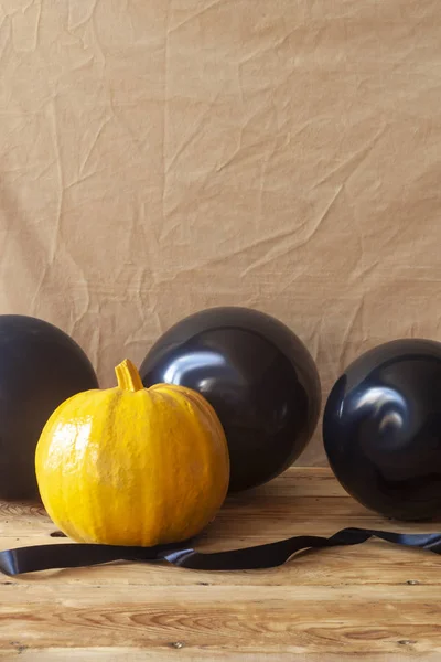 Halloween pumpkin and air balloons on the table — Free Stock Photo