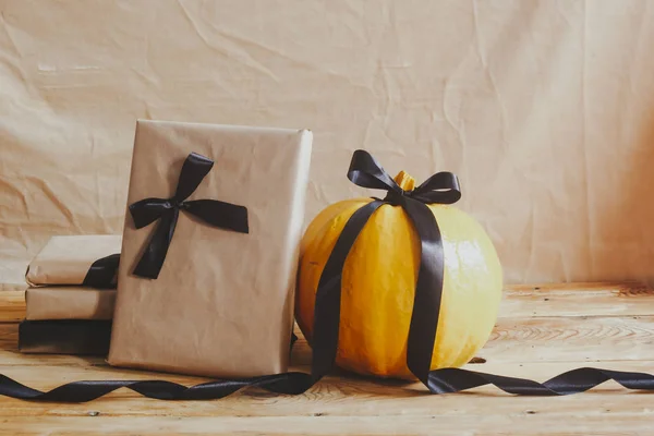 Halloween vieren. Oranje en zwarte pompoenen met ingerichte geschenkdozen — Stockfoto