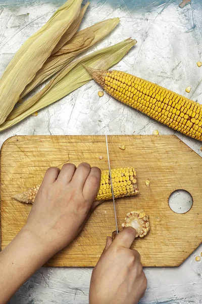 Wanita tangan memotong jagung manis di pemotongan papan — Stok Foto