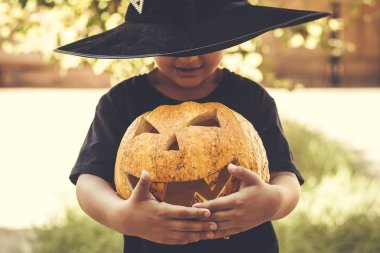 Cadılar bayramı balkabağı tutan çocuk