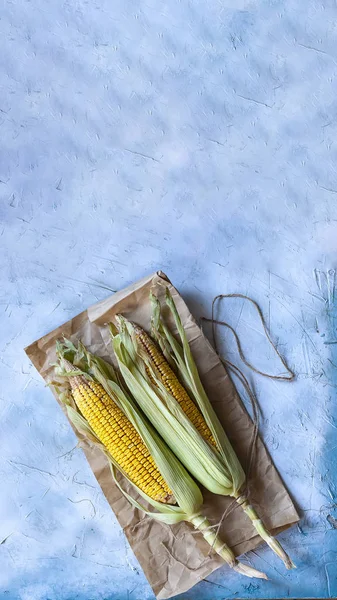 Corns op de kolf op een heldere achtergrond — Gratis stockfoto