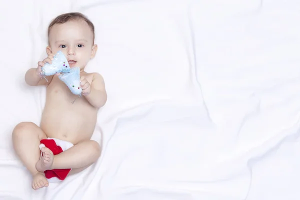 9 maand baby jongen met Santa Claus hoed. Kerst ochtend. Kleine Kid spelen. — Stockfoto