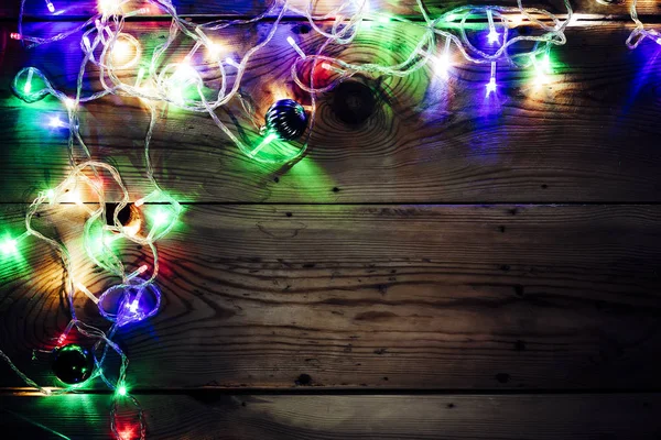 크리스마스 장식 조명입니다. 나무에 크리스마스 화환 조명입니다. 소박한 갈색 판자에 다채로운 Xmas 전구 — 스톡 사진