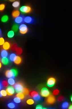 Xmas arka plan görüntüsü. Dekoratif Noel ışıkları bokeh. Karanlık Noel çelenk ışıkları Defocused görüntü