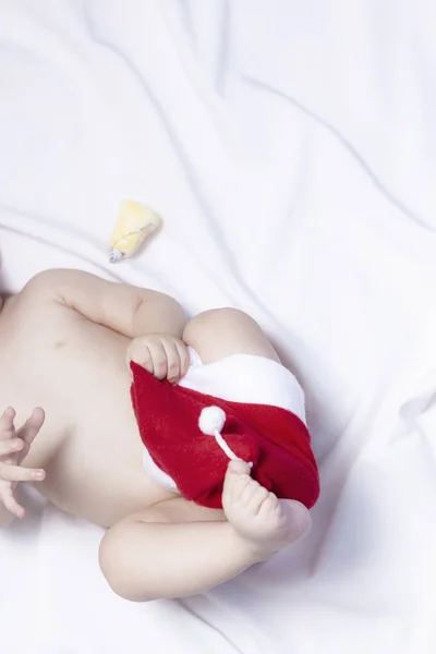 Menino de 9 meses com chapéu de Pai Natal. Manhã de Natal. Criança brincando . — Fotografia de Stock