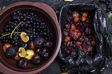 Taze topalmış sonbahar meyveleri. Koyu masa ahşap masa üzerinde siyah üzüm ve incir