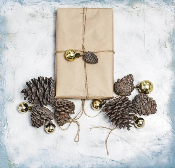 Decoraciones navideñas. Conos de pino, caja de regalo decorada con juguetes de árbol de Navidad y conos de pino . — Foto de Stock