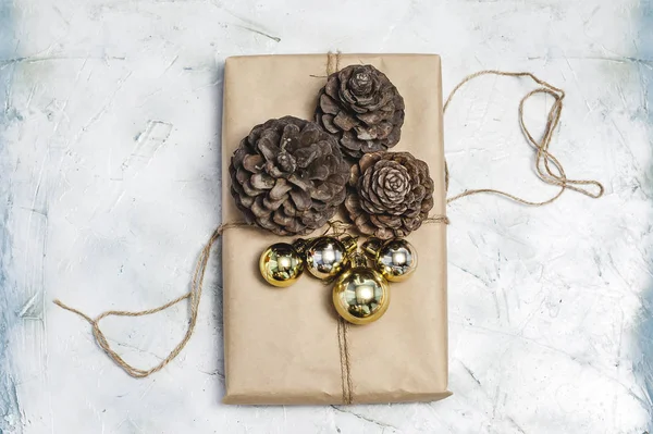 Dekorasi Natal. Buah cemara, kotak hadiah dihiasi dengan mainan pohon Natal dan kerucut pinus . — Stok Foto
