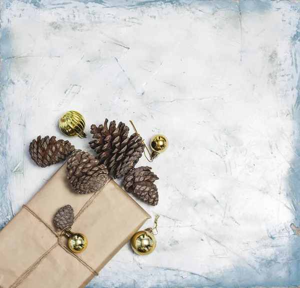 Decoraciones navideñas. Conos de pino, caja de regalo decorada con juguetes de árbol de Navidad y conos de pino . — Foto de Stock