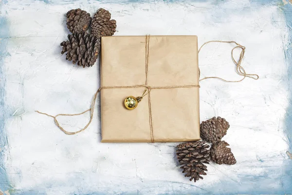 Рождественские украшения. Сосновые шишки, подарочная коробка, украшенная рождественскими игрушками и шишками из сосны . — стоковое фото