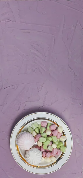 Placa de malvaviscos sobre fondo rosa. Dulces de malvavisco de colores con espacio para copiar —  Fotos de Stock