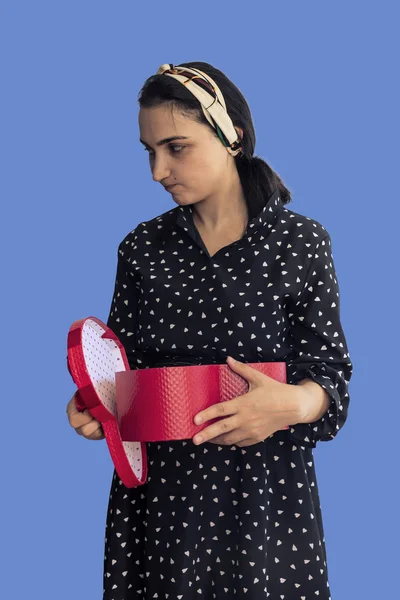 Unhappy woman opening a red gift box