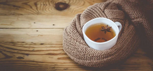 Чашка гарячого чаю на дерев'яному столі. Холодні осінні або зимові дні — стокове фото