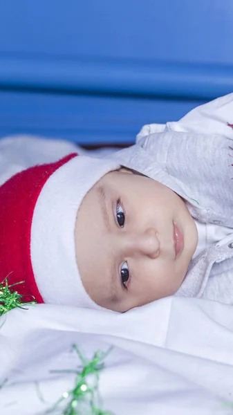 Petit garçon drôle Santa jouer avec Noël ou guirlande festive nouvelle année de vacances. Bébé garçon de 1 an en bonnet Père Noël . — Photo
