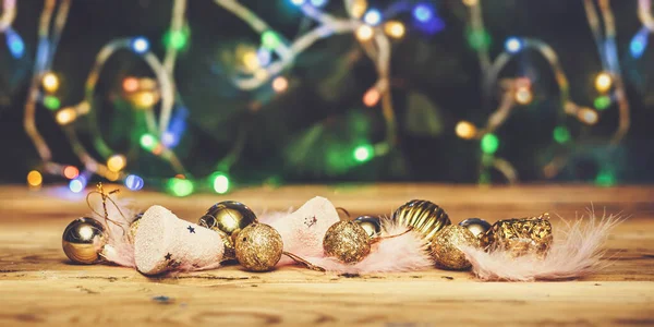 Cute Christmas toys with light pink feathers on wooden table