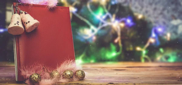 Egy nagy karácsonyi kívánságkönyv karácsonyfa játékokkal és dekorációkkal a fa asztalon. Olvasott bőr jegyzettömb - ajándék karácsonyra vagy szilveszterre — Stock Fotó