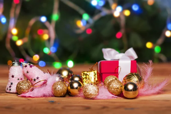 Weihnachtsspielzeug auf Holztisch gegen den geschmückten Weihnachtsbaum. Weihnachtsdekoration auf Holz. Hintergrundbild Urlaub — Stockfoto