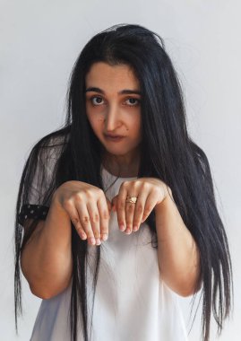 Şirin bir kadının komik portresi. Cadılar Bayramı Portresi. Kadın komik tavşan tavşanı gösteriyor. Kadın komik yüz ifadeleri yapıyor. Siyah saçlı, neşeli bir kızın portresi.