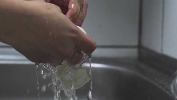 Vrouw wassen knoflook onder stromend water — Stockvideo