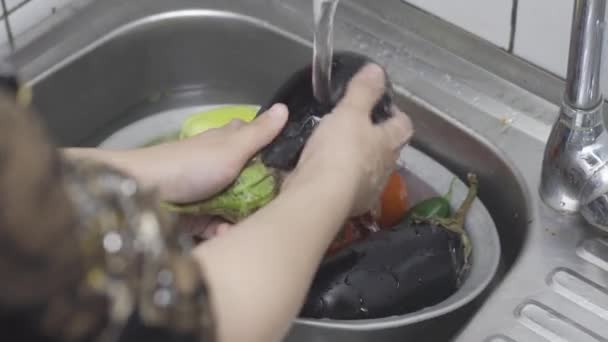 Kvinna som tvättar nyplockade ekologiska grönsaker i durkslag — Stockvideo