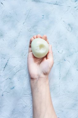 Kadın eli soğanı tutuyor.