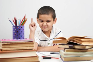 Düşünceli okul çocuğunun fikri, parmağını kaldırması. Biliyorum.