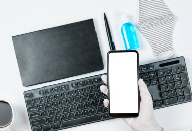 COVID-19 sonrası dönem. Tıbbi eldivenli bir memur elinde boş ekranlı akıllı bir telefon tutuyor.