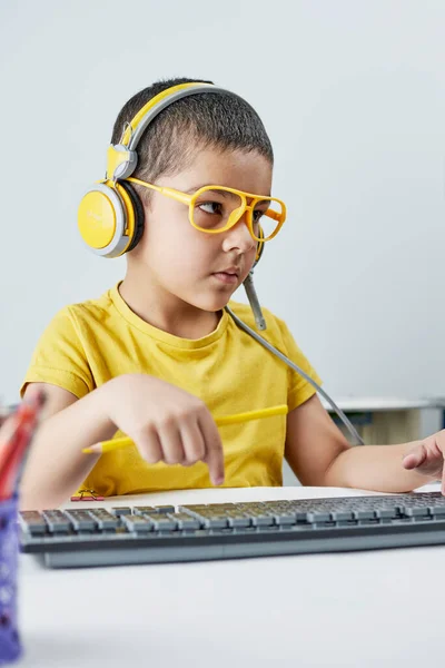 Evde eğitim. Çevrimiçi yabancı dil öğrenen sarı okullu şirin bir çocuk. — Stok fotoğraf