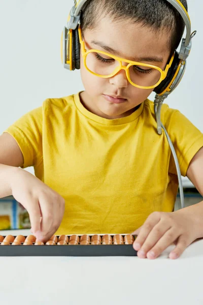 Schoolboy with abacus. Young kid training mental arithmetic — Stock Photo, Image