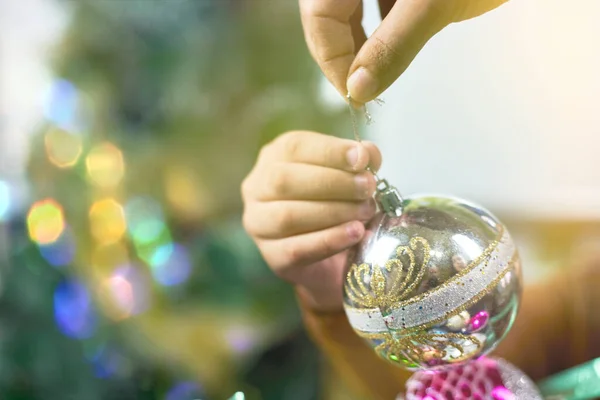 Son helps mom to decorate Christmas tree