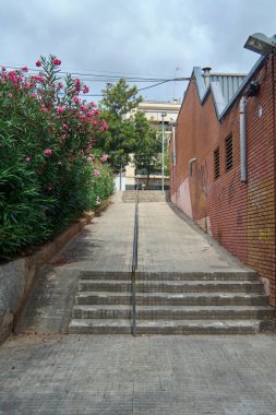 Viladecanlar. Barselona - 05 Eylül 2025: Ulaşılabilirlik rampası ve yayalar için merdiven kombinasyonu. Görüntü, tüm vatandaşlar için şehir planlama ve katılımı temsil ediyor..