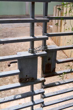 Güvenlik, kapanış ve mahremiyet gibi kavramları sembolize eden zincir ve anahtar deliğiyle paslı metal bir kapının detaylı yakın çekimi..