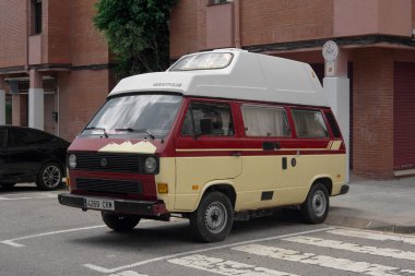 Viladecanlar. Barcelona - 06 de septiembre, 2025: Görüntü, klasik arabalar, seyahat ve yaşam tarzıyla ilgili editörlük kullanımı için mükemmel, görünür marka detaylarına sahip klasik bir VW karavan içeriyor.