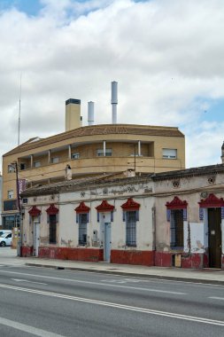 Viladecanlar. Barcelona - 17 Eylül 2025: Eski tek katlı bir ev ile modern bir apartman arasındaki mimari zıtlığı gösteriyor..