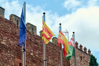 Viladecanlar. Barcelona - 18 Eylül 2025: Avrupa Birliği ve bölgesel ve ulusal hükümetlerin bayrakları Viladecan 'daki tarihi bir binanın üzerinde dalgalanıyor.