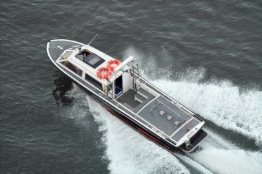 Venedik. İtalya - 24 Eylül 2025: Hızlı bir devriye ya da pilot botun yüksek hızda gri denizi keserek arkasında büyük ve dinamik bir beyaz uyanış yaratması.