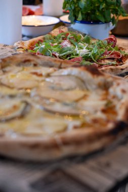 Çıtır çıtır ve aromatik malzemeli nefis ev yapımı pizza. Güzel bir restoran atmosferinde sunuluyor. Paylaşım ve lezzet için ideal.