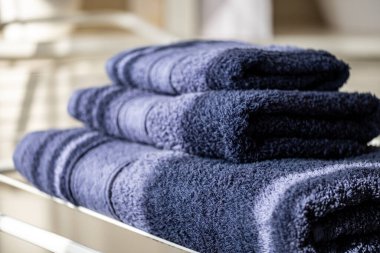 Yumuşak, düzgünce katlanmış havlular düzenli bir şekilde düzenlenir, sıcak banyo atmosferini taze dokular ve kullanışlı, düzenli bir görünüm ile güçlendirir.