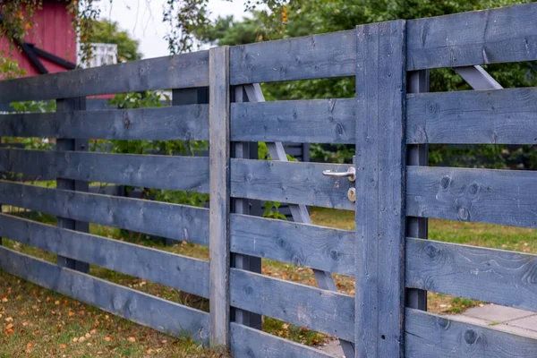 Kırsal ahşap çit, doğal dokuları ve sağlam yapıları ön plana çıkaran büyüleyici bir mavi kaplama içeriyor, açık havada fotokopi alanı ile koruyucu bir sınır oluşturuyor.