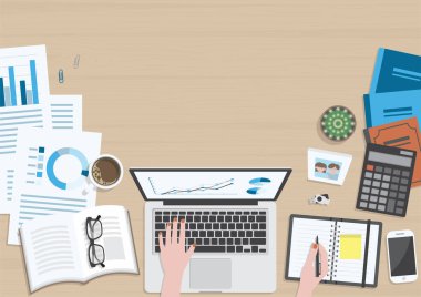 Üst tabakadan ahşap dokuma masa dizüstü bilgisayarda çalışan ve ofis malzemeleri, kahve fincanı, fotoğraf çerçevesi, kitaplar ve belge ile düzenleyicide yazan bir kadın eli masa.