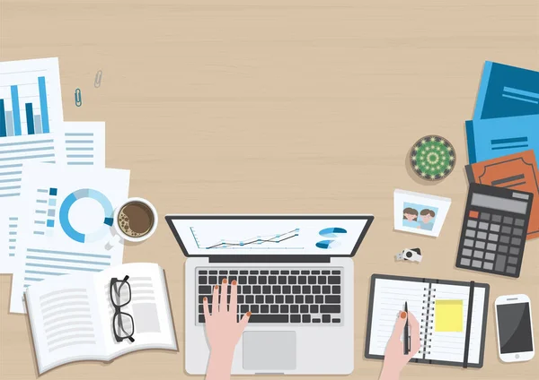 Üst tabakadan ahşap dokuma masa dizüstü bilgisayarda çalışan ve ofis malzemeleri, kahve fincanı, fotoğraf çerçevesi, kitaplar ve belge ile düzenleyicide yazan bir kadın eli masa.