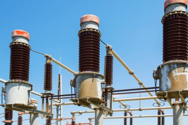 Mavi gökyüzü üzerinde enerji santrali detayı, kırmızı yüksek gerilim yalıtım