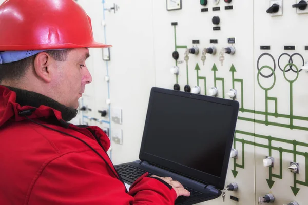 Técnico en rojo con instrumentos de lectura portátil en planta de energía — Foto de Stock