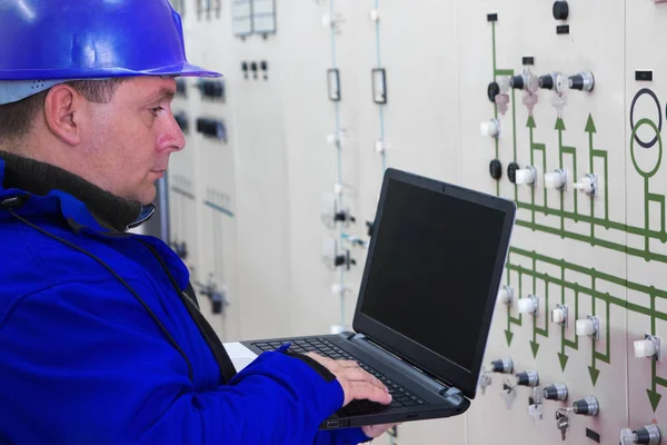 Techniker in blau mit Laptop-Lesegeräten im Stromplan — Stockfoto