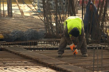 Metal çubukları çerçeve takviyesine dönüştüren işçiler