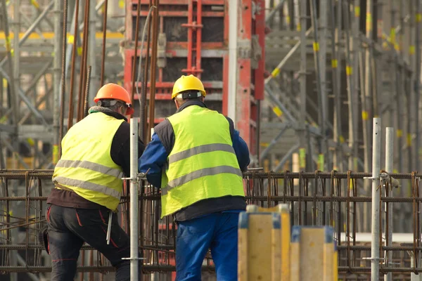 Dois trabalhos em amarelo no canteiro de obras — Fotografia de Stock