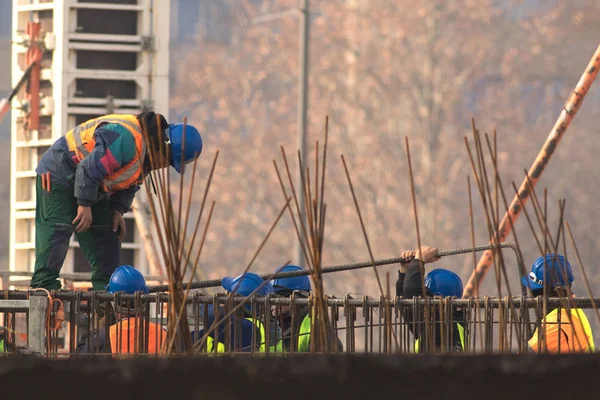 Grupo de constructores con casco azul en la obra — Foto de Stock