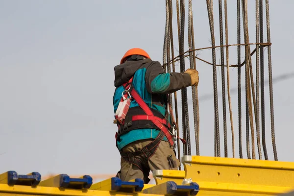 Trabajador con cinturón de seguridad y casco en la zona de reconstrucción — Foto de Stock