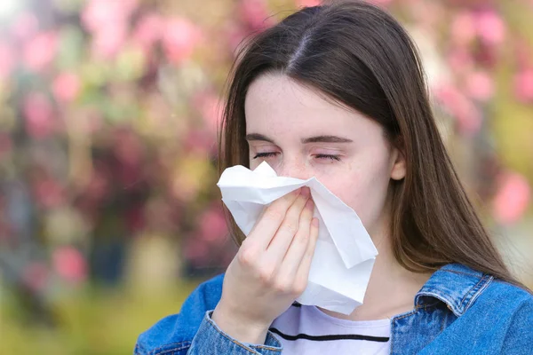 Erken ilkbaharda çiçekler üzerinde polen alerjisi olan kız — Stok fotoğraf